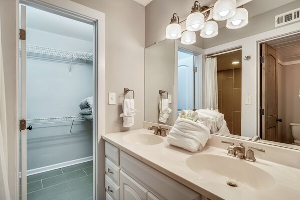 Une salle de bain avec deux lavabos, un grand miroir et un porte-serviettes.