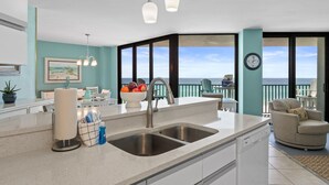 A kitchen with a large island, double sink, and a view of the ocean. - AquaVista by Book That Condo (Panama City Beach)