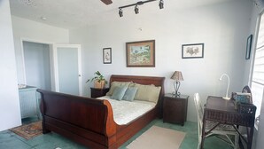 Een slaapkamer met een houten bed, een nachtkastje, een lamp, een stoel en een raam met zonwering.