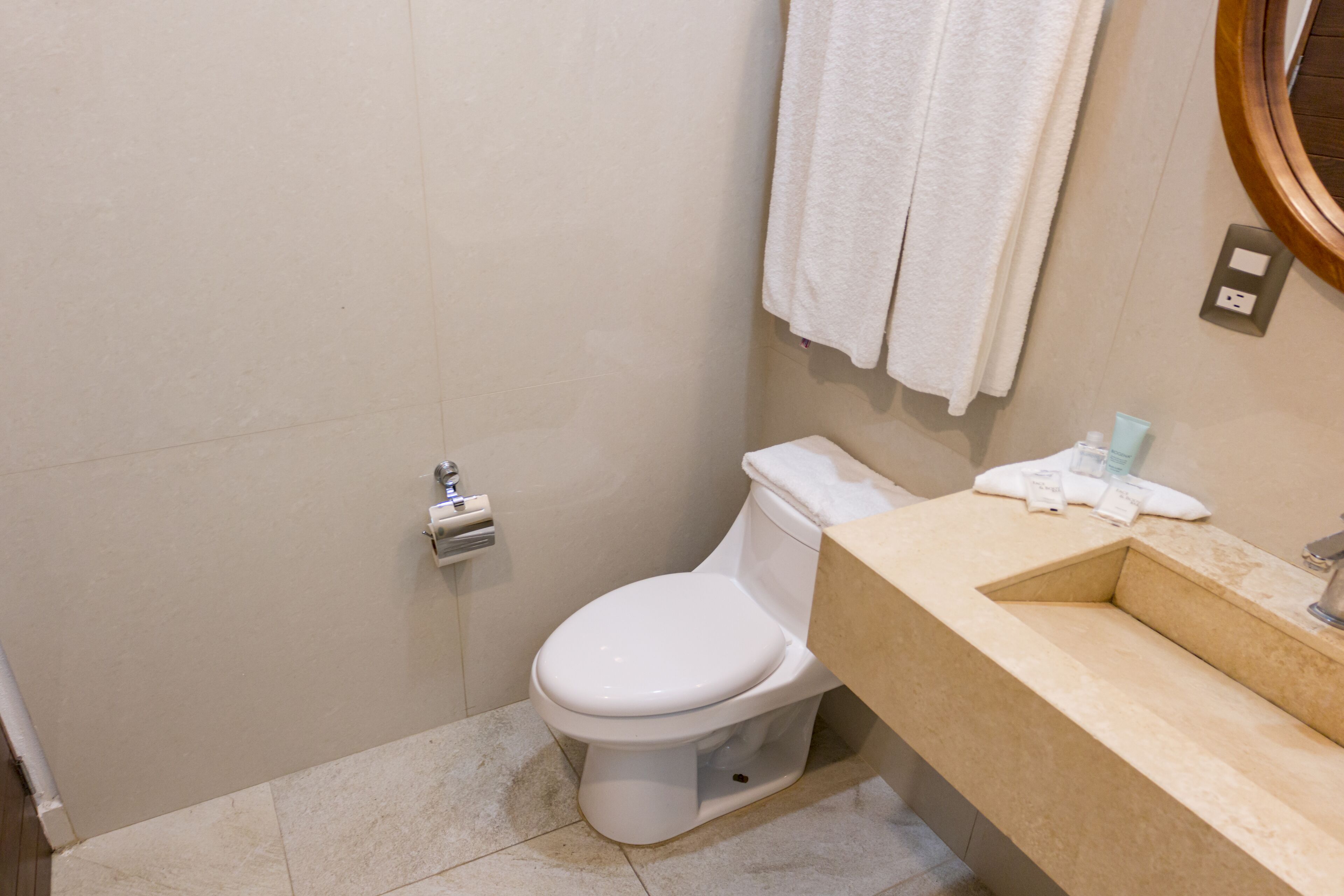 Ein Badezimmer mit Toilette, Waschbecken und Handtuchhalter.