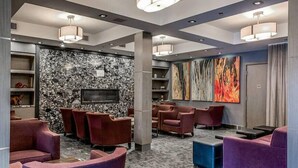A modern lounge area with plush seating, a stone wall, and abstract art. - Beautiful 2 Bed 2 bath Pool Waterslide & Hot tubs (Canmore)