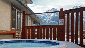 Un bain à remous entouré d’une clôture en bois et agrémenté d’un panneau d’avertissement signalant la présence de verglas.