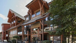 A multi-story lodge with a prominent wooden facade, large windows, and a sign for Chinook Lodge. - Star Suite 2 Bed 2 bath condo with 3 fireplaces (Canmore)