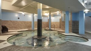 A pool area with a central fountain, tiled walls, and pillars. - Star Suite 2 Bed 2 bath condo with 3 fireplaces (Canmore)