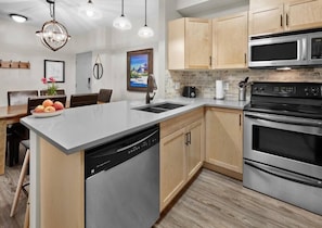 Enjoy cooking in this well-equipped kitchen with a central island, dishwasher, and stainless steel range hood.