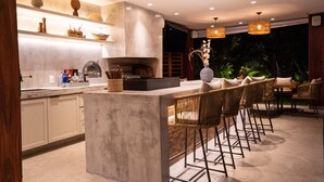 Una cocina moderna con barra, con encimera de mármol, armarios de madera y una isla grande con taburetes de bar.