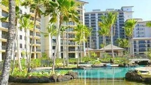 Un resort con edifici a più piani, una piscina e palme.