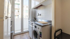Una cucina compatta con lavatrice, un piccolo bancone e vista esterna.
