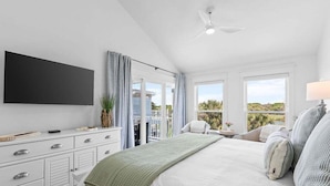 A bedroom with a bed, a TV, a ceiling fan, and a view of the outdoors. - 2BR/2BA Gorgeous Views! Steps to Beach,Pool,Club House & Restaurants! Amenity access included (Seabrook Island)