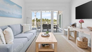 A modern living room with a sofa, coffee table, and a TV. - 2BR/2BA Gorgeous Views! Steps to Beach,Pool,Club House & Restaurants! Amenity access included (Seabrook Island)