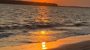 A beach with a sunset over the water, reflecting on the sand. - 2BR/2BA Gorgeous Views! Steps to Beach,Pool,Club House & Restaurants! Amenity access included (Seabrook Island)