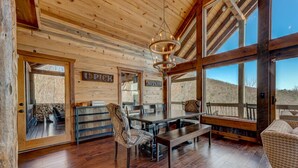 Un intérieur en bois comprenant un coin repas, un banc et une vue sur l’extérieur.