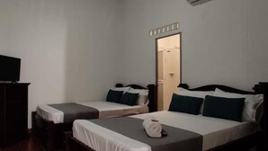 A hotel room with two single beds, a TV, and a wardrobe. - Hotel Villa Ángel (Neiva)