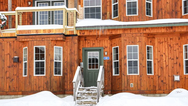 Un bâtiment en bois avec une porte verte et une plaque portant le numéro 41.