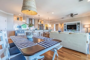 Una sala de estar moderna con sofá, mesa de comedor y zona de cocina.