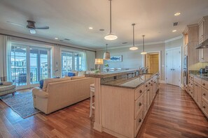 Una cocina amplia con una isla grande, armarios de madera y un comedor con sofá y sillas.