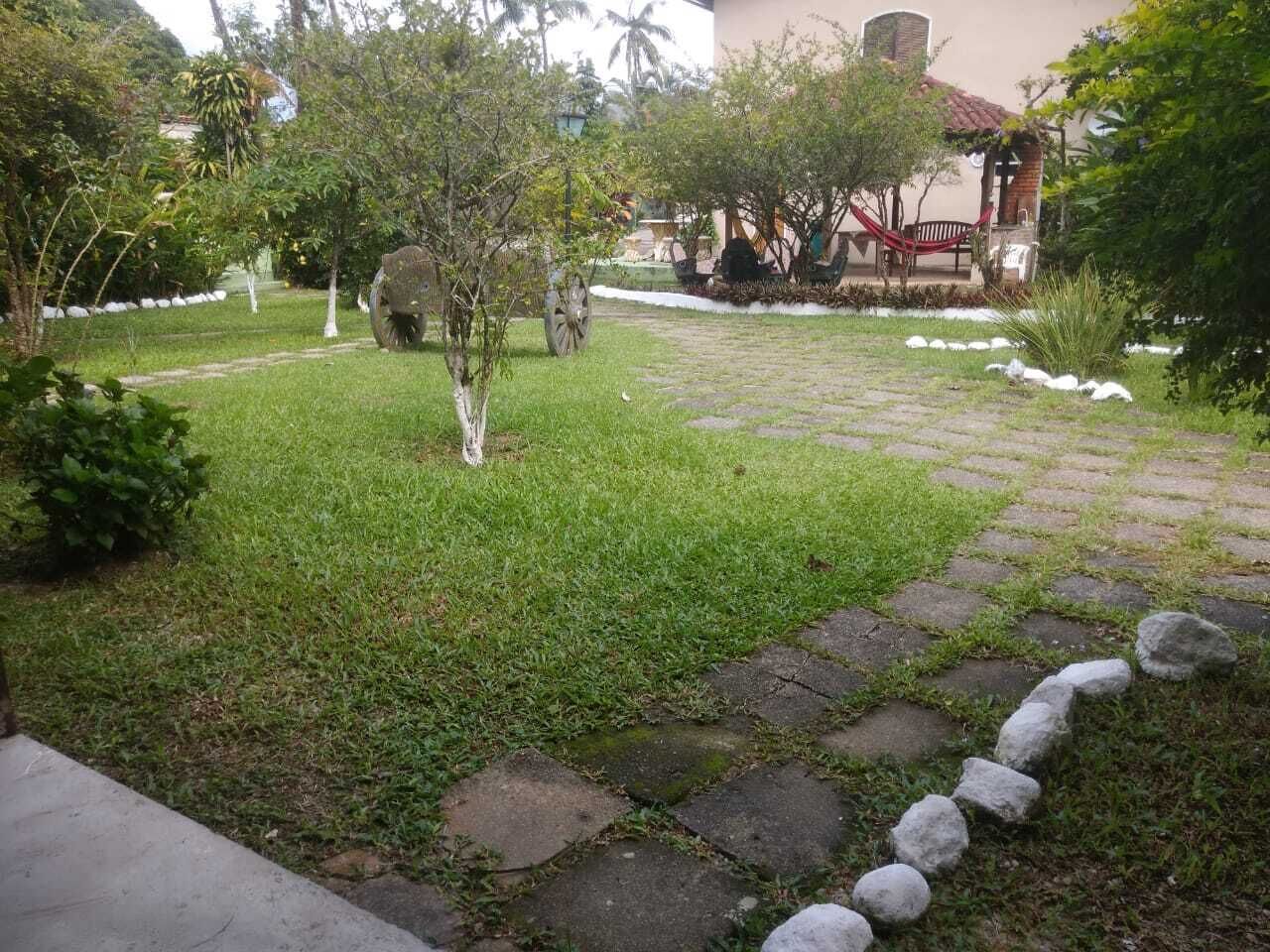 Un sendero en el jardín con piedras para pisar, una hamaca y un pequeño árbol.