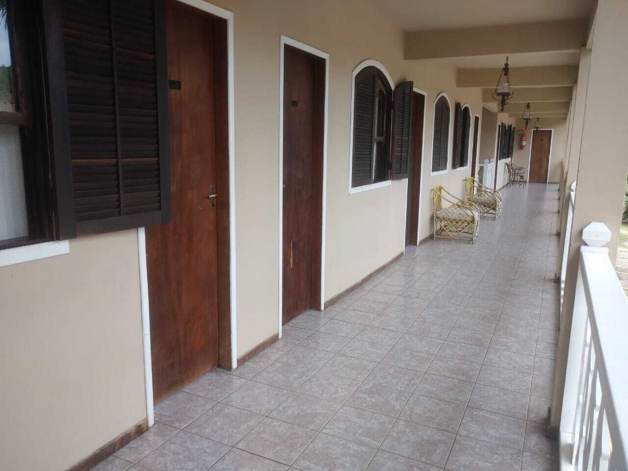 Un pasillo con puertas, ventanas y piso de baldosas.