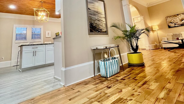 Un vaste espace de vie doté d’un plancher en bois, un coin repas avec cuisine, et un plafond haut avec des lambris en bois.
