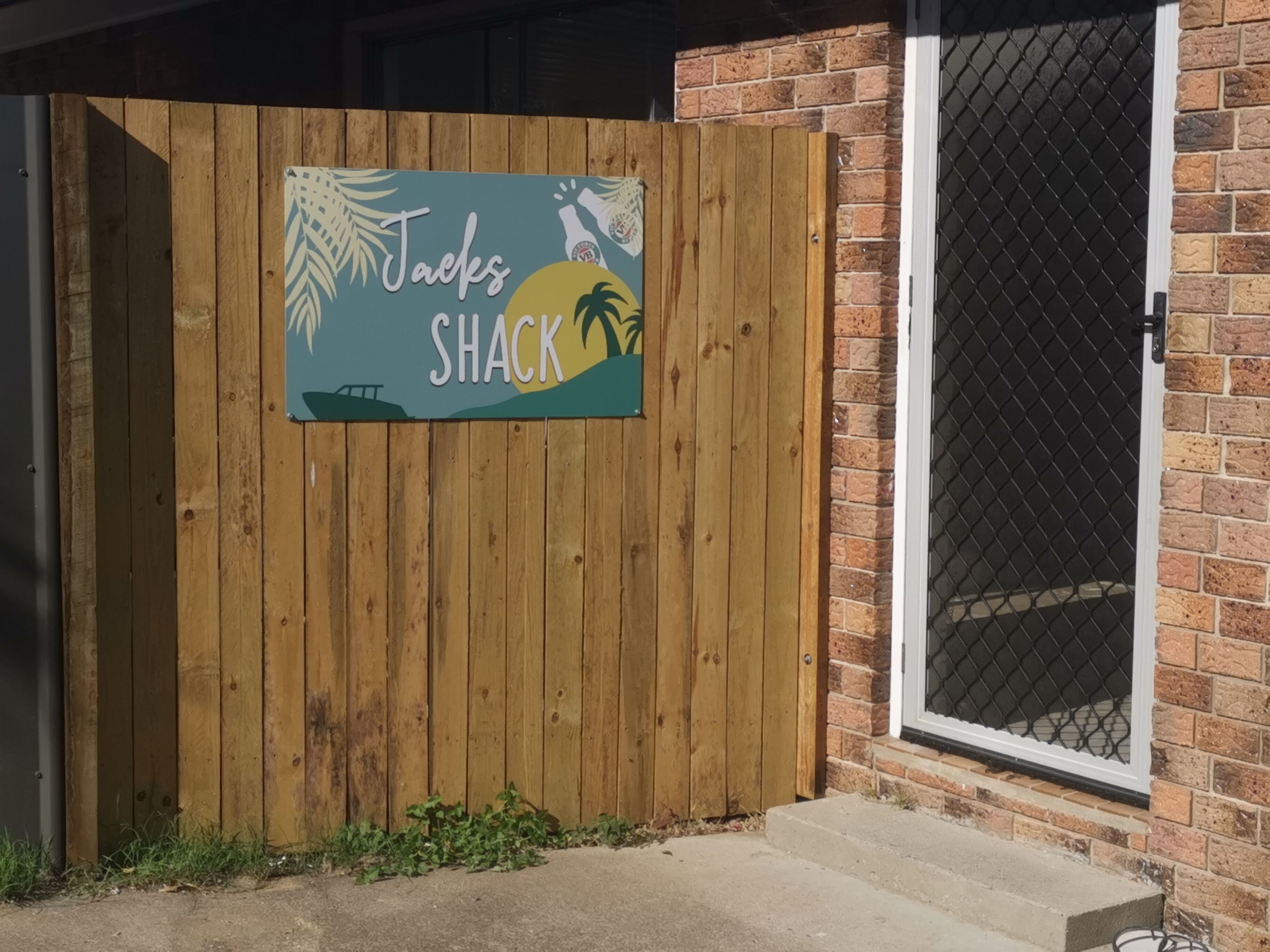 A wooden fence with a sign that reads "Jacks Shack."