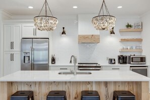 Modern kitchen with a central island, double sink, and water dispenser.