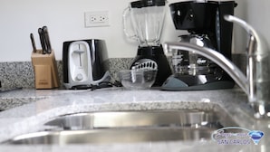 Una cuina amb un rentaplat, un torradora, una batedora i una cafetera.