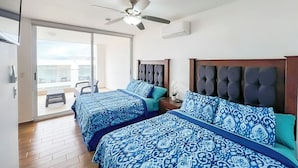 Une chambre d’hôtel avec deux lits, un ventilateur de plafond et une vue sur le balcon.