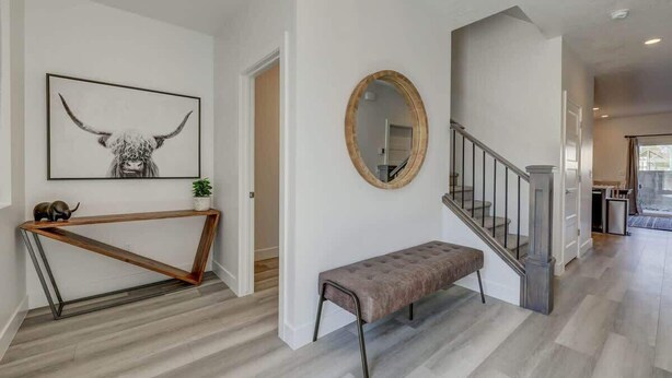 A modern interior with a wooden console table, a bench, a mirror, and a staircase. - The Vue #25 | Luxury Poolside Townhouse (Saint George)