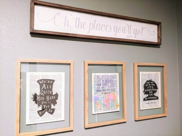 A wall with three framed quotes and a sign above them.