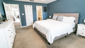 A bedroom with a bed, nightstands, a dresser, and a ceiling fan. - Live the Salt Life in Golden Dog's Destin Rental (Destin)