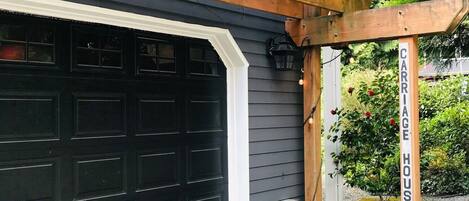 A garage with a wooden pergola above it, labeled "PARK HERE" and "CARRIAGE HOUSE".