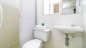 A bathroom with a toilet, a sink, and a mirror. - Hotel Ayenda Los Tres Pinos (Bogotá)