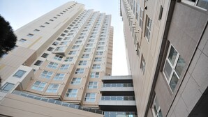 A high-rise building with multiple floors, large windows, and a modern architectural design. - Hotel BELLIA (Busan)