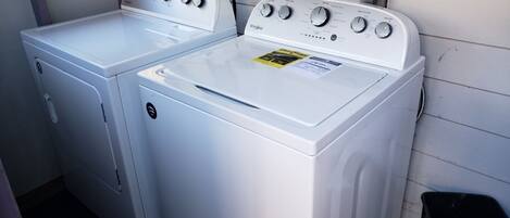 Un lavadero con dos lavadoras y secadoras Whirlpool blancas.