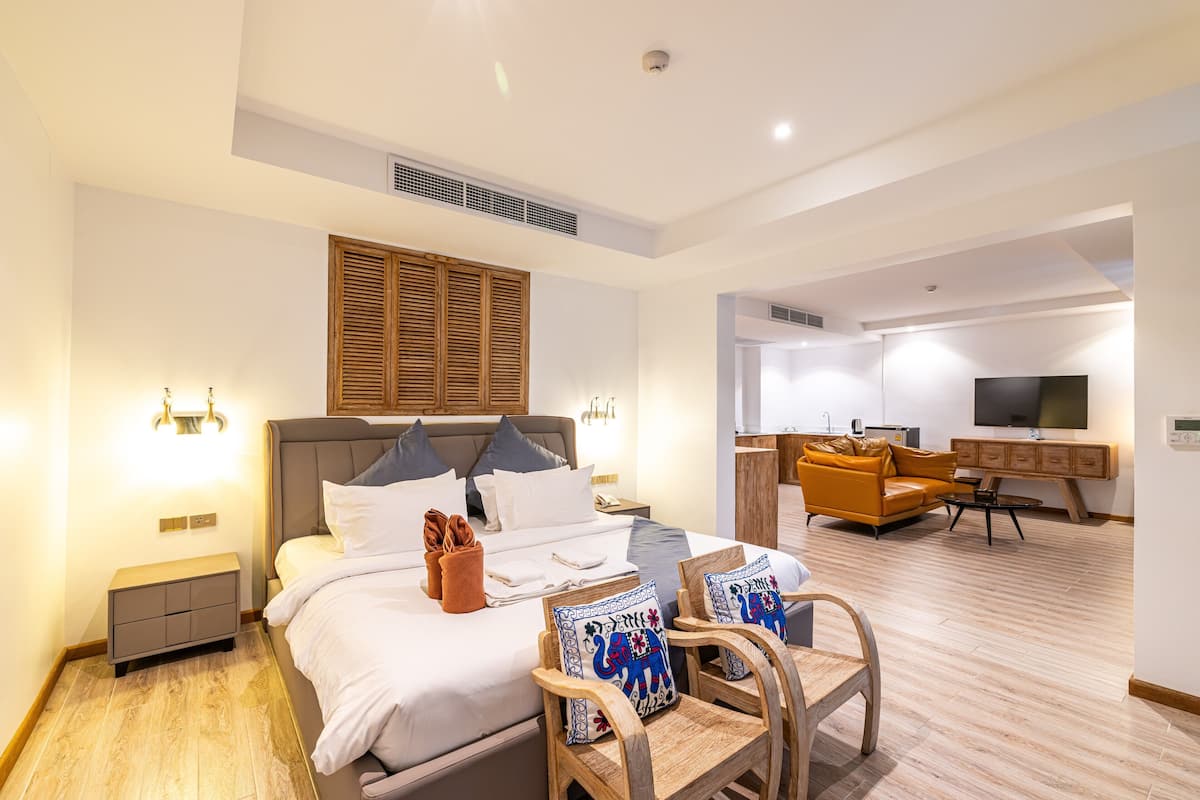 Ein modernes Hotelzimmer mit einem großen Bett, einem Schreibtisch, einer Couch und einem Fernseher.