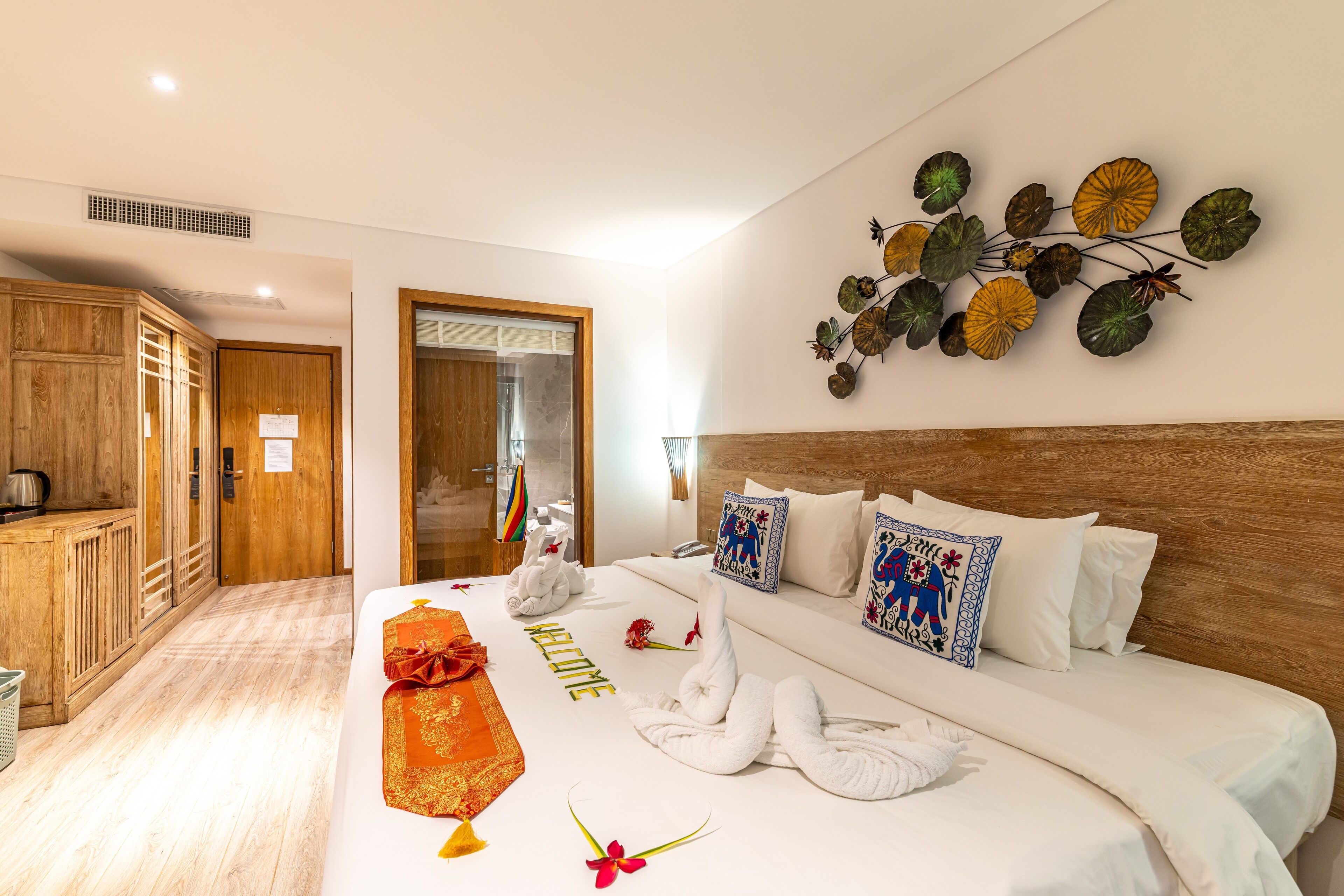 Une chambre d’hôtel avec un lit bien fait, une armoire en bois et un élément décoratif mural.