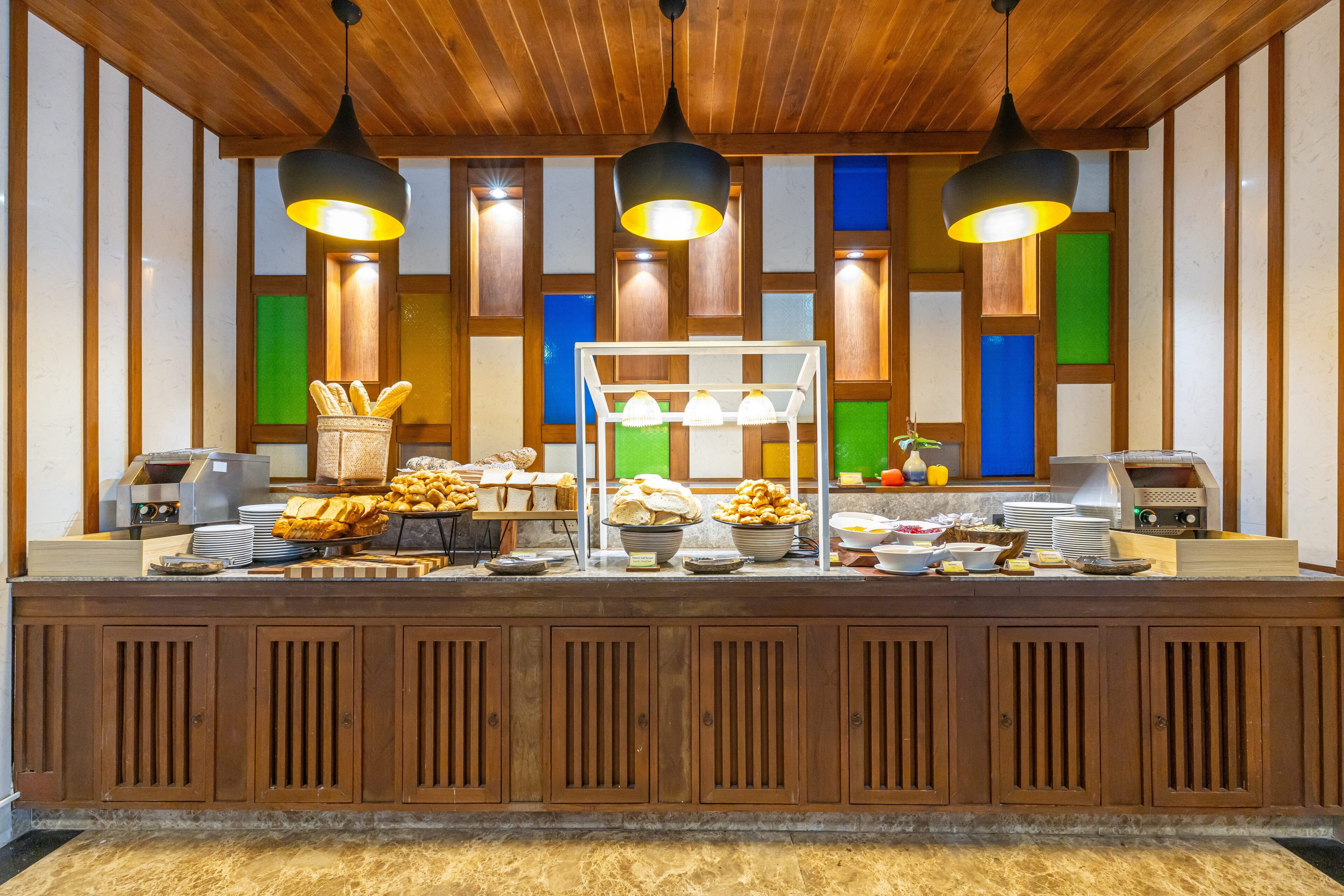 A buffet counter with various food items and a coffee machine.