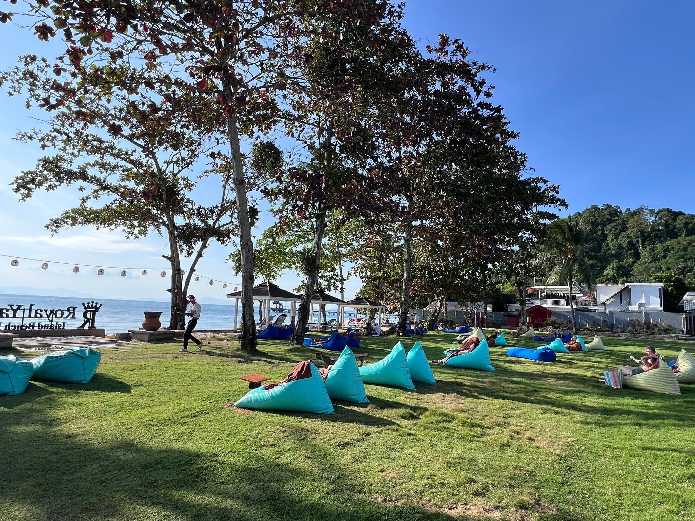 A grassy area with blue bean bags and a gazebo.