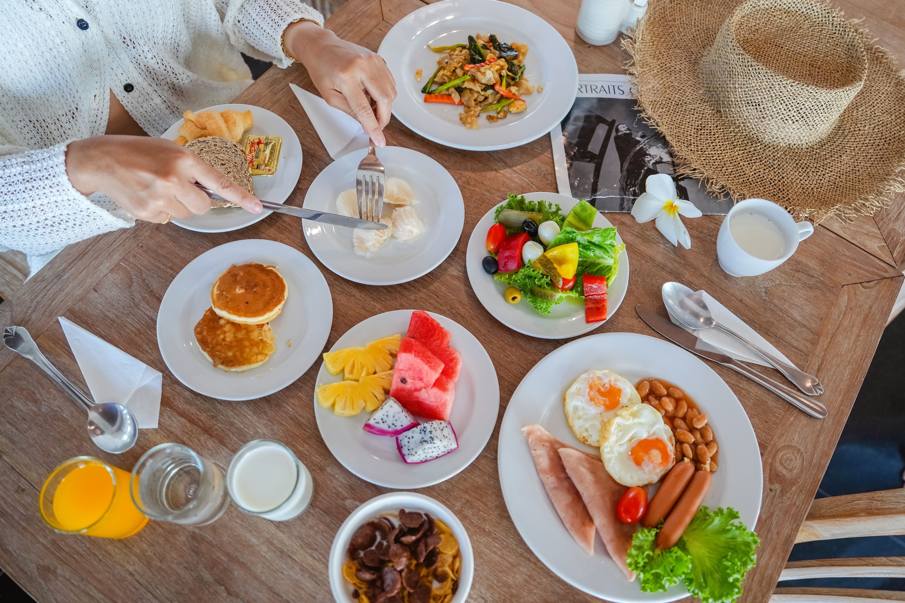 A table with various breakfast items including pancakes, eggs, and fruits.