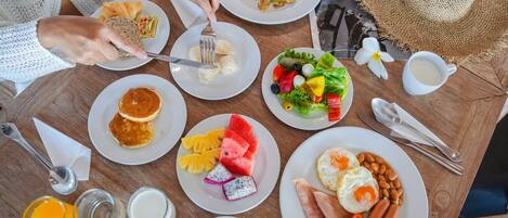 A table with various breakfast items including pancakes, eggs, and fruits.