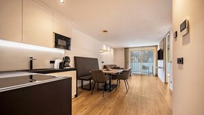 Una cocina moderna con comedor, suelo de madera y un ventanal grande.