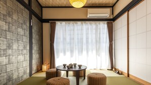 A traditional Japanese-style room with tatami flooring, a low table with tea set, and sliding shoji doors. - Urban Stay Oshiage (Tokyo)