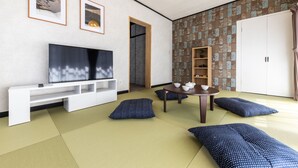 A modern living room with tatami flooring, a flat-screen TV, a wooden table with teaware, and a wardrobe. - Urban Stay Oshiage (Tokyo)