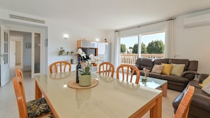 A modern living room with a brown leather sofa, a dining table with chairs, and a balcony with a railing. - Eclari 4 pax - Javea, Costa Blanca (Javea)