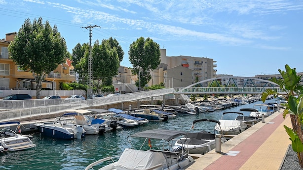 A marina with various boats docked, a pedestrian bridge, and buildings in the background. - Eclari 4 pax - Javea, Costa Blanca (Javea)