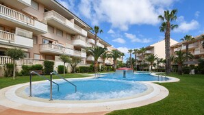 A hotel with a pool area, palm trees, and a clear blue sky. - Eclari 4 pax - Javea, Costa Blanca (Javea)