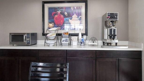 A kitchen with a microwave, coffee maker, and a framed painting on the wall. - Red Roof Inn Houston North - Fm1960 and I-45 (Houston)