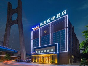 Un hotel con fachada moderna, amplias ventanas y un letrero llamativo.