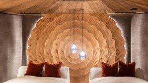 A room with a unique wooden wall design, two white sofas with brown cushions, and pendant lights. - Kuschel-chalet - Chalets Grossmitt (Pertisau)
