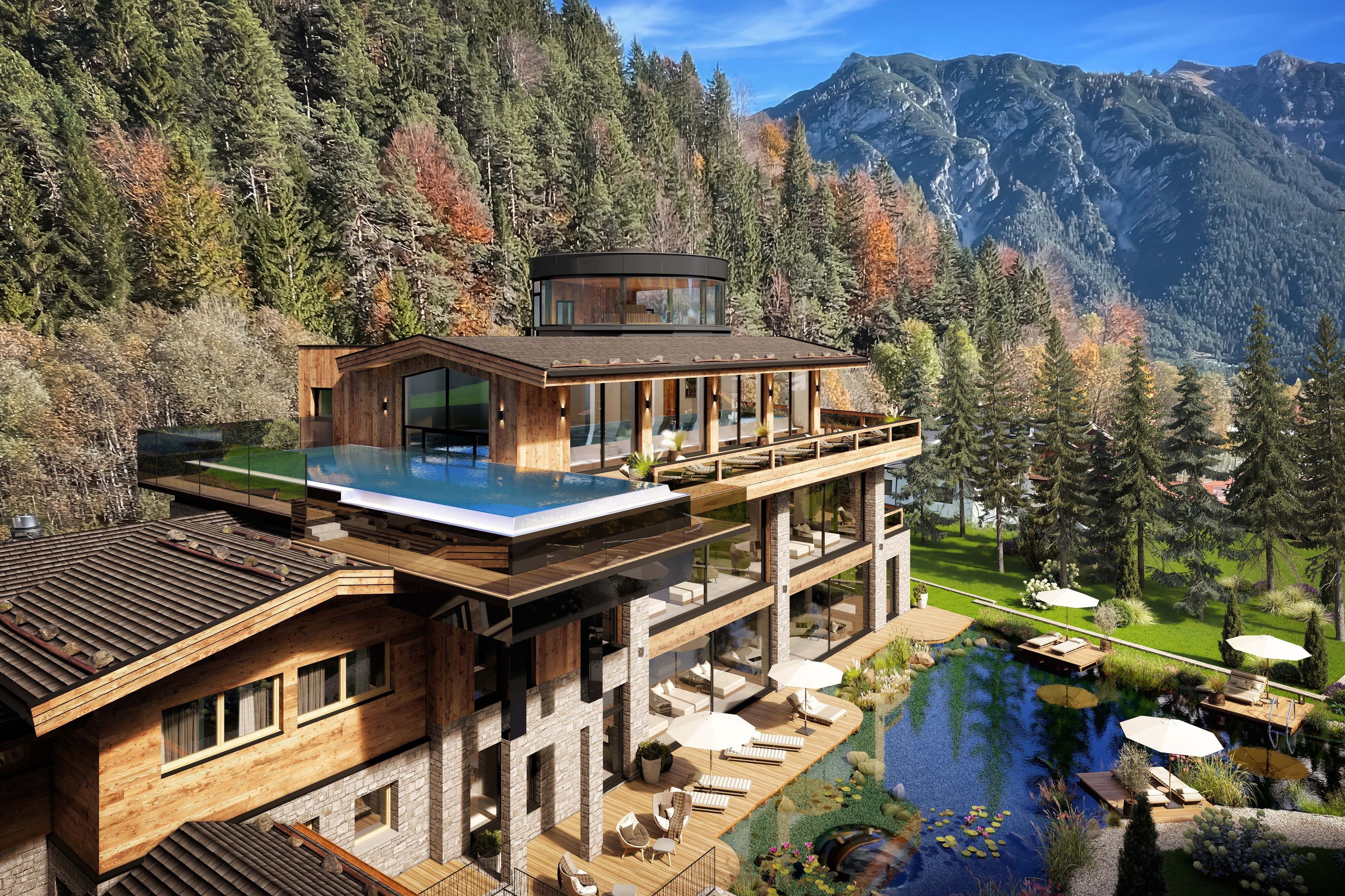 Een modern huis met een glazen overloopzwembad, een houten terras en een berg op de achtergrond.